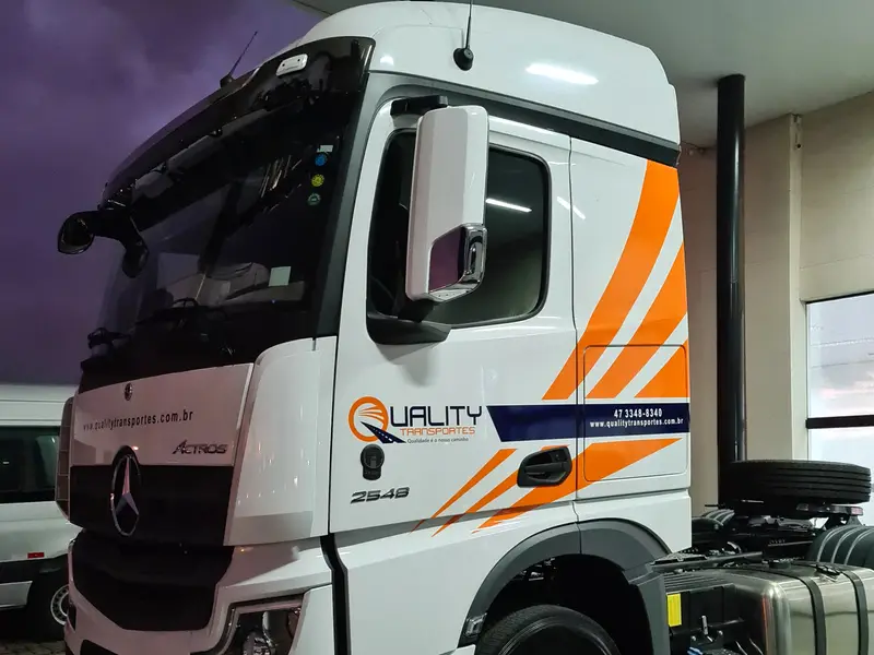 Cabine Mercedes da Quality Transportes com grafismo