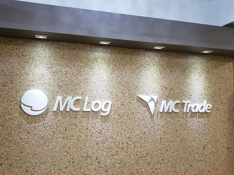 Logotipos da MC Log e MC Trade em parede de recepção