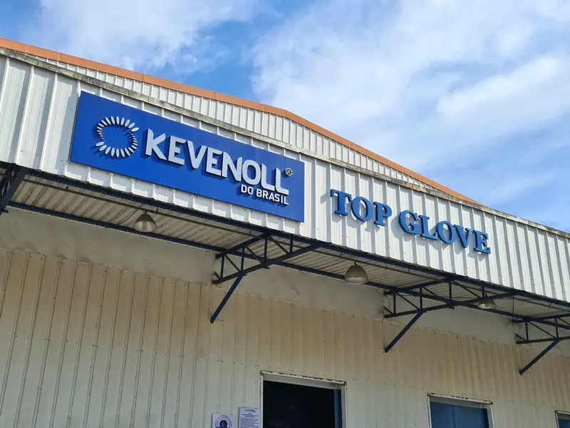 Letreiros da Kevenoll e da Top Glove em galpão