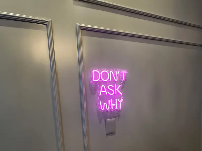 Frase em neon LED rosa instalada na parede